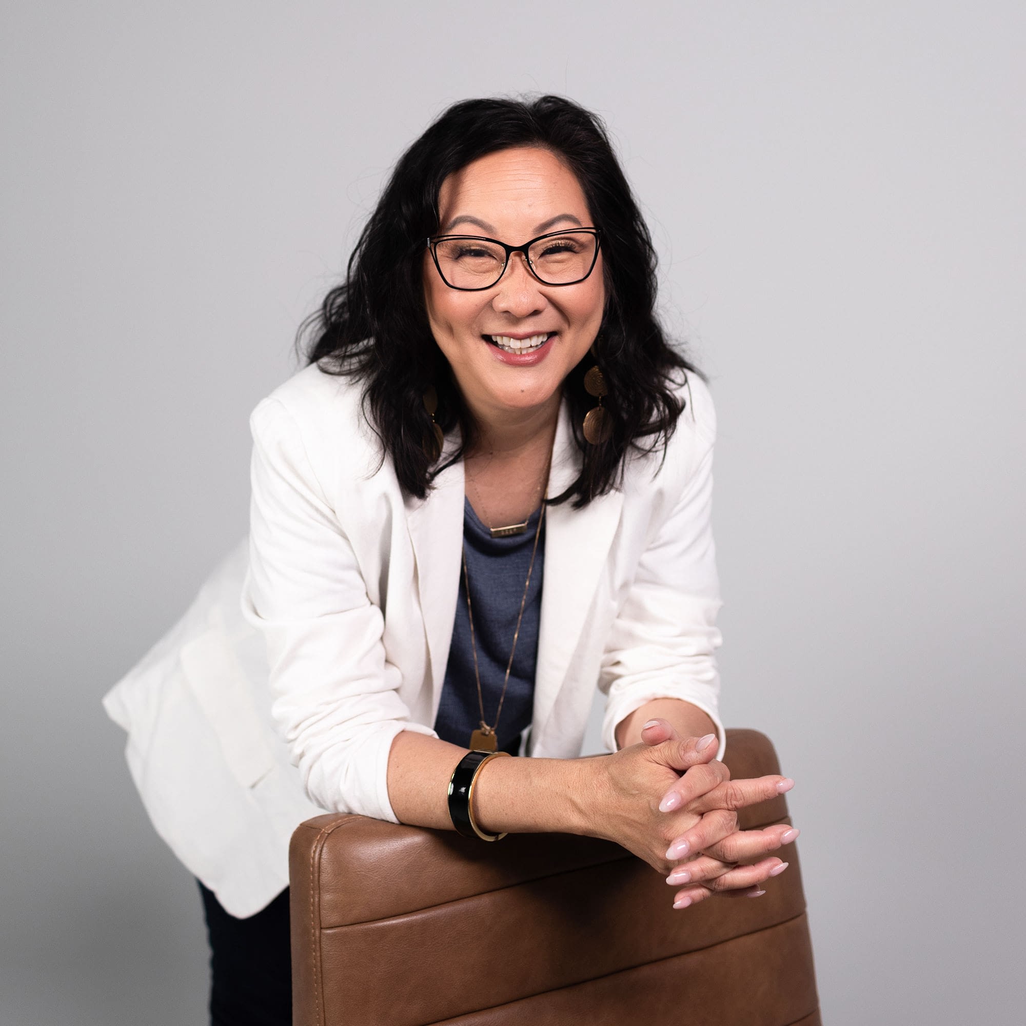 Smiling woman in glasses and white jacket