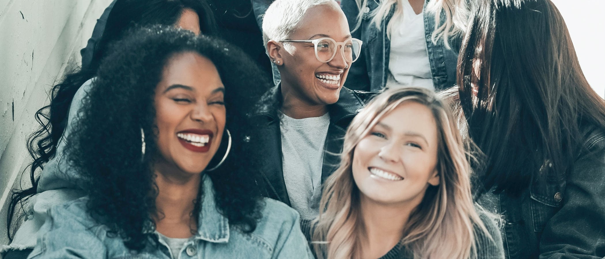 A group of women sitting on stairs having a good time