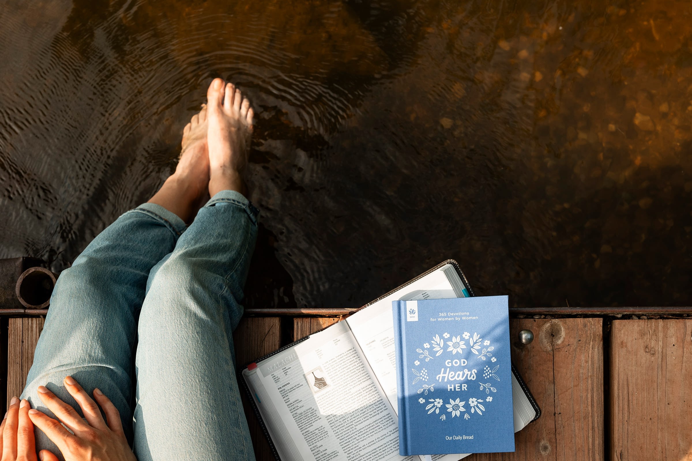 Person reading by the water's edge.