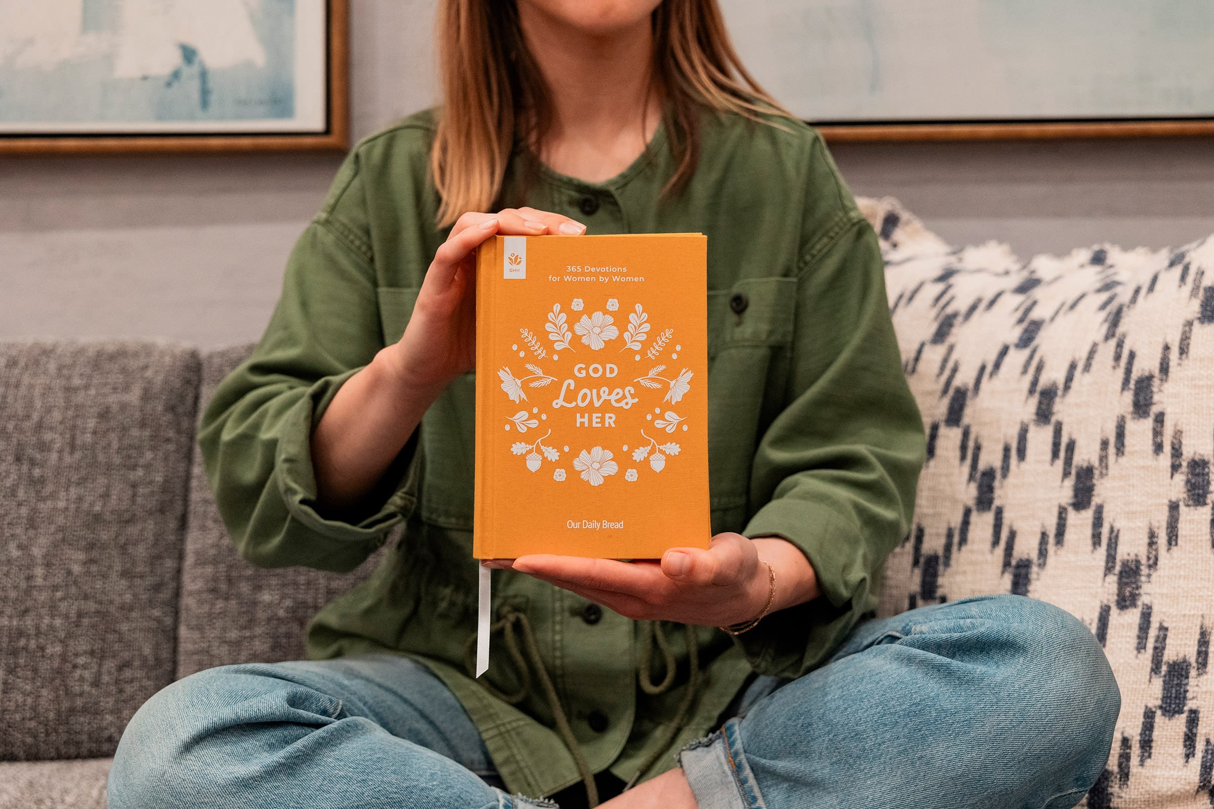 Woman holding God Loves Her devotion book.