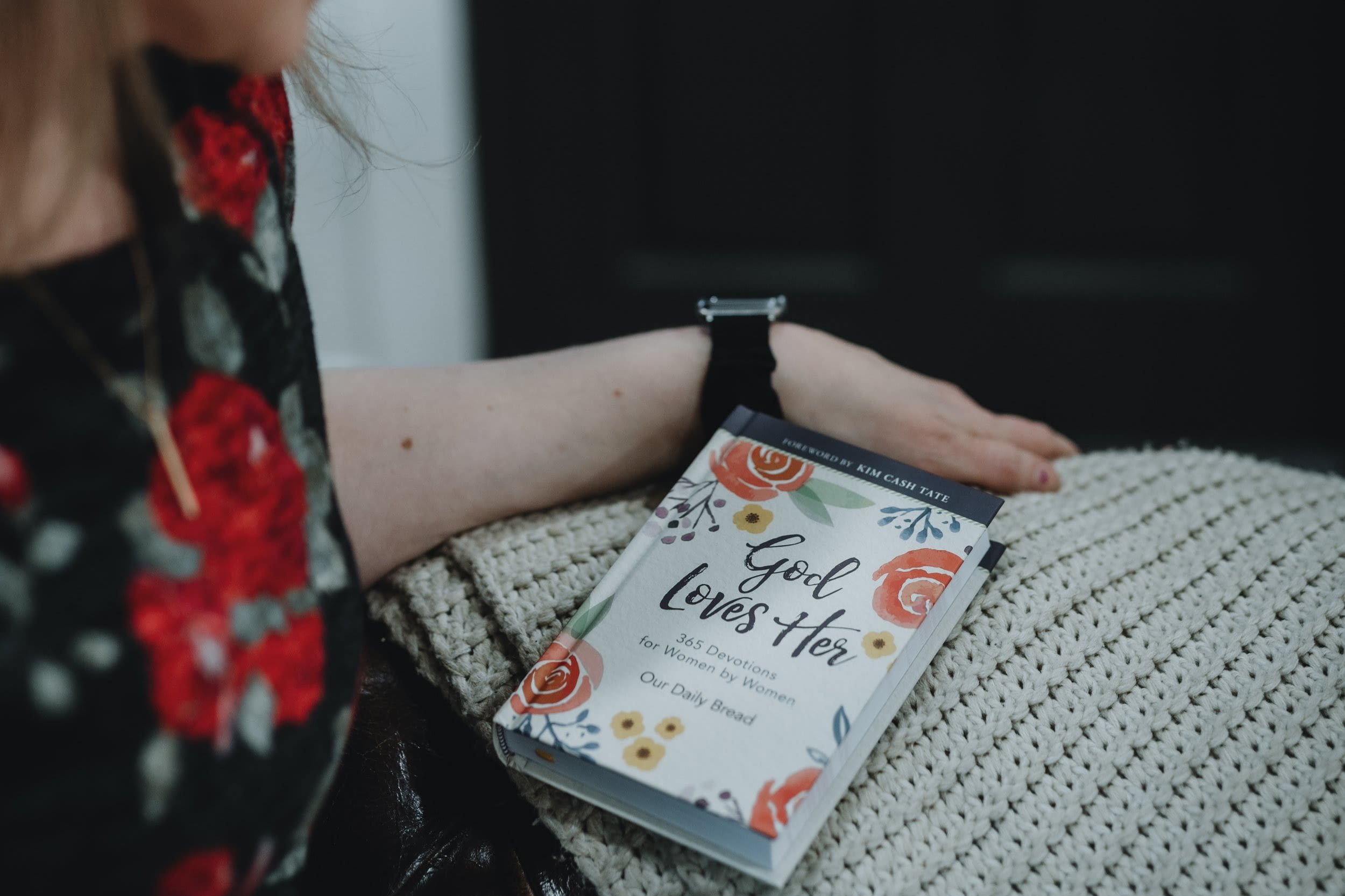 Person holding God Loves Her devotional book.